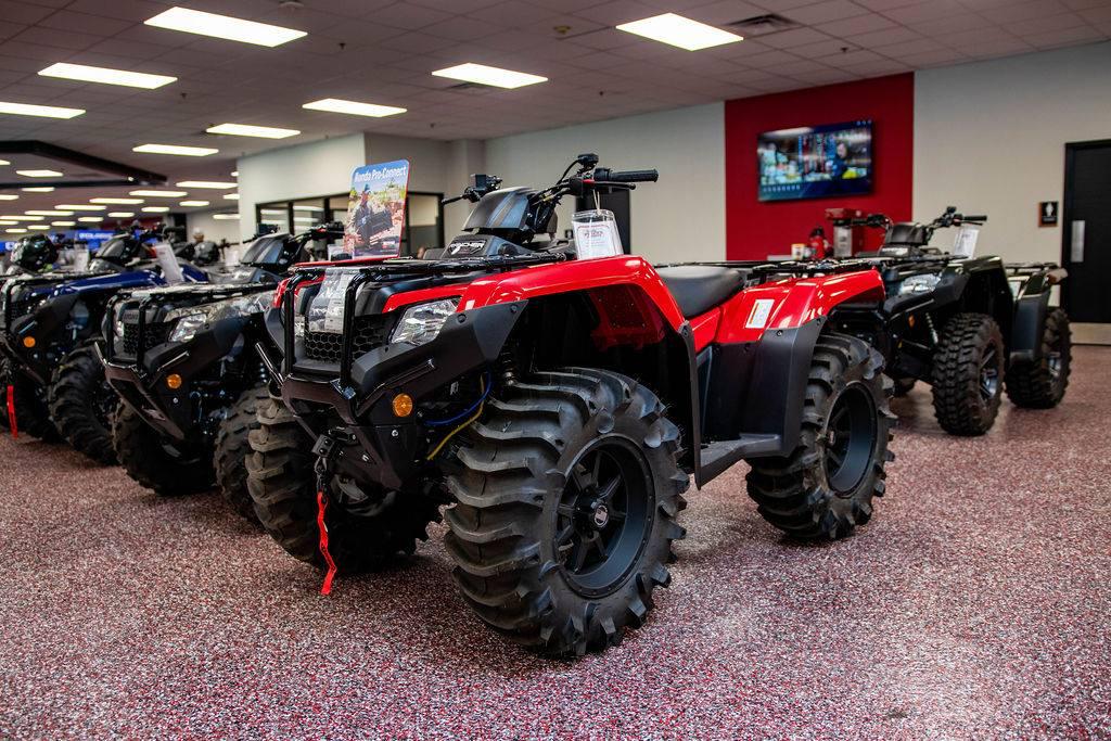 Honda ATV with front rack accessories on the Friendly Powersports Slidell showroom floor